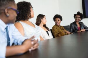 AHLA women in hotels image depicts women talking at a meeting